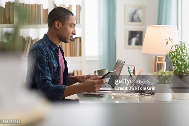 black businessman using cell phone at desk - confident desk man text space stock pictures, royalty-free photos & images