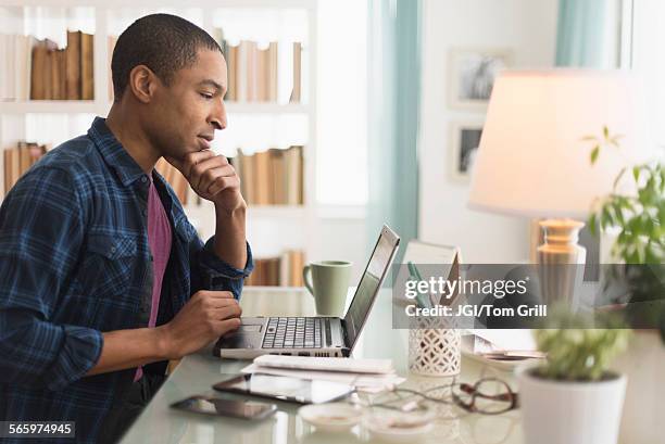 black businessman working on laptop at desk - black business owner ストックフォトと画像