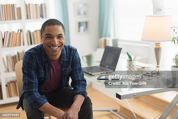 black businessman smiling at desk - black business owner ストックフォトと画像