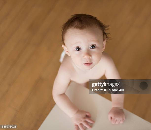 caucasian baby looking up at table - couchtisch stock-fotos und bilder