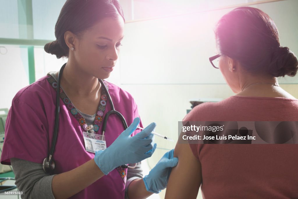 Nurse giving patient injection in hospital