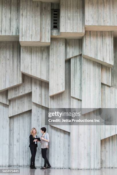 caucasian businesswomen talking under office wall art - seattle people stock pictures, royalty-free photos & images