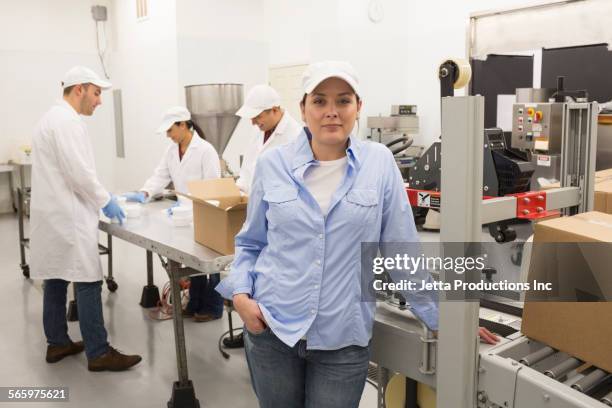 worker standing with machinery in factory - grupo pequeno de pessoas imagens e fotografias de stock