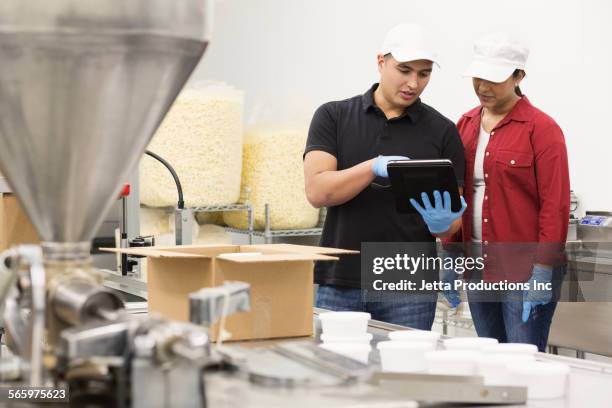 workers using digital tablet in factory - the popcorn factory stock pictures, royalty-free photos & images