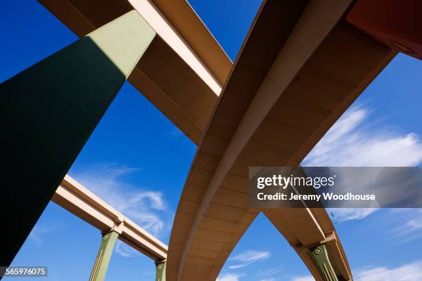 low angle view of highway overpasses under blue sky - high five interchange stock pictures, royalty-free photos & images