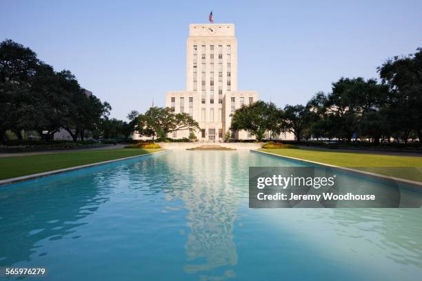 houston city hall over pond in urban park, houston, texas, united states - houston stockfoto's en -beelden