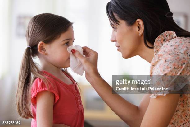 mother wiping nose of daughter with tissue - blowing nose stock pictures, royalty-free photos & images