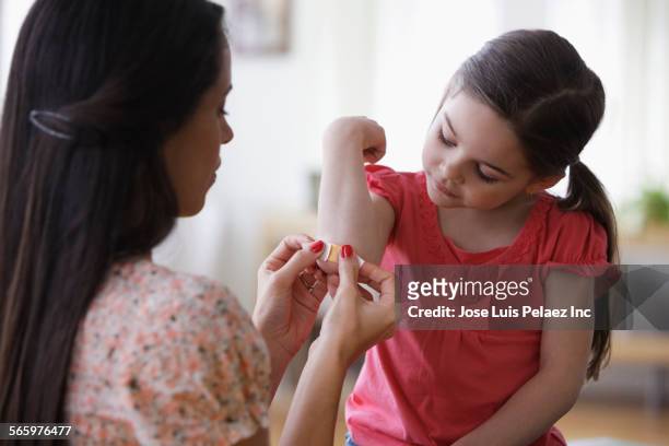 mother bandaging elbow of daughter - wounded 個照片及圖片檔