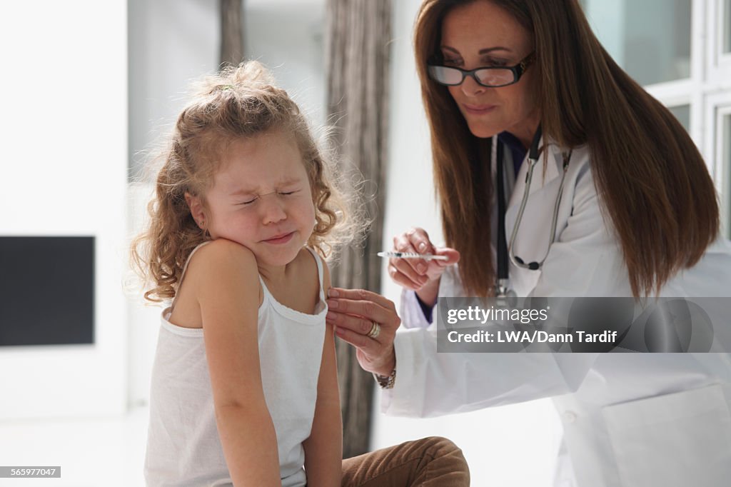 Caucasian doctor vaccinating girl
