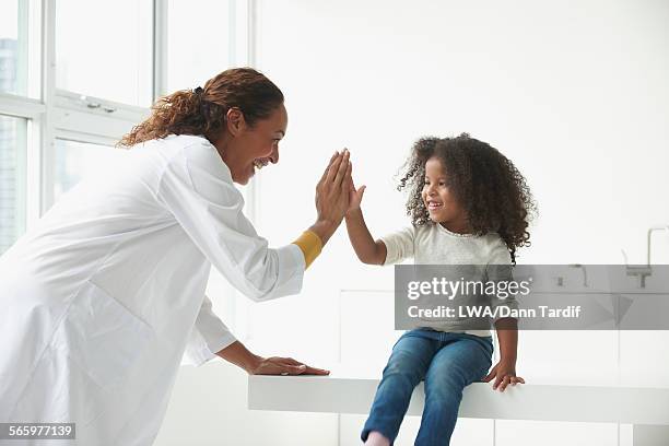 doctor and girl high-fiving in office - facial expression girl office stock pictures, royalty-free photos & images