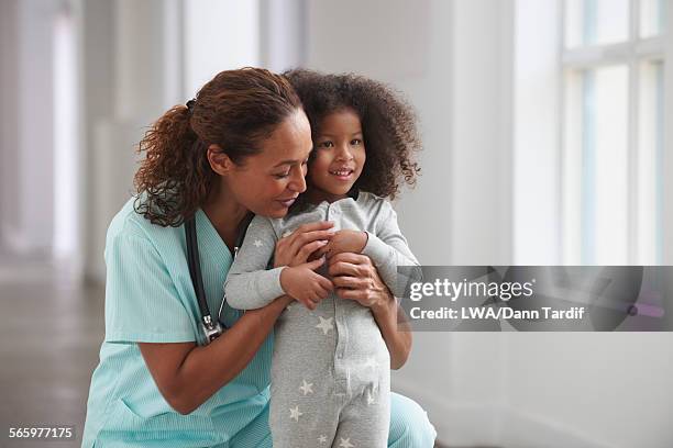 nurse hugging girl in hallway - jamaican ethnicity imagens e fotografias de stock