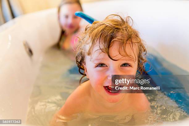 caucasian children playing with mermaid tail in bath - house flipper fotografías e imágenes de stock