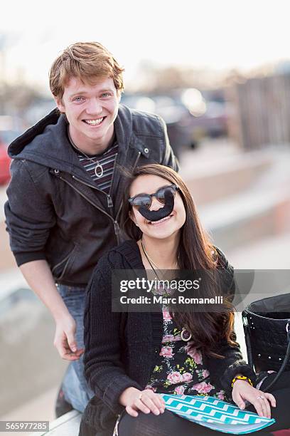 teenage couple playing with fake mustache - fake of indian girls stock pictures, royalty-free photos & images