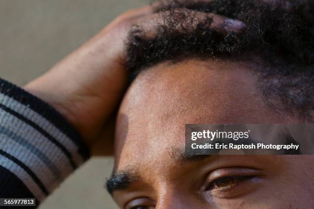 close up of hand in hair of mixed race man - forehead foto e immagini stock