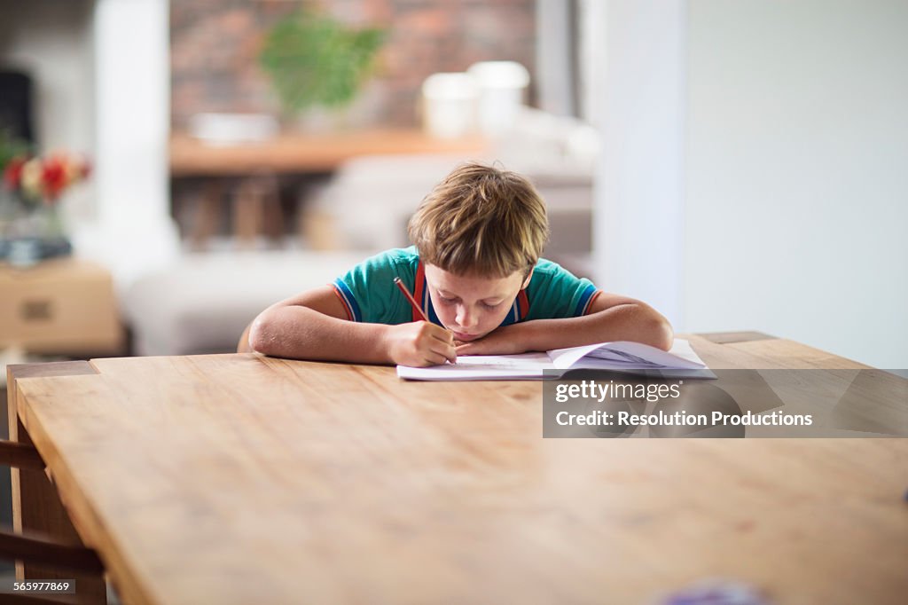 Caucasian boy drawing at table