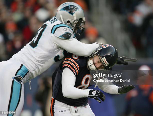 Quarterback Rex Grossman of the Chicago Bears takes a shot from Julius Peppers of the Carolina Panthers after throwing a pass in the NFC Divisional...