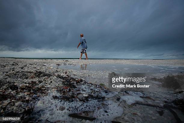 Local resident Bob Barchie takes a walk along the shore in front of the TradeWinds Hotel in St. Pete Beach, Florida after the remnants of Tropical...