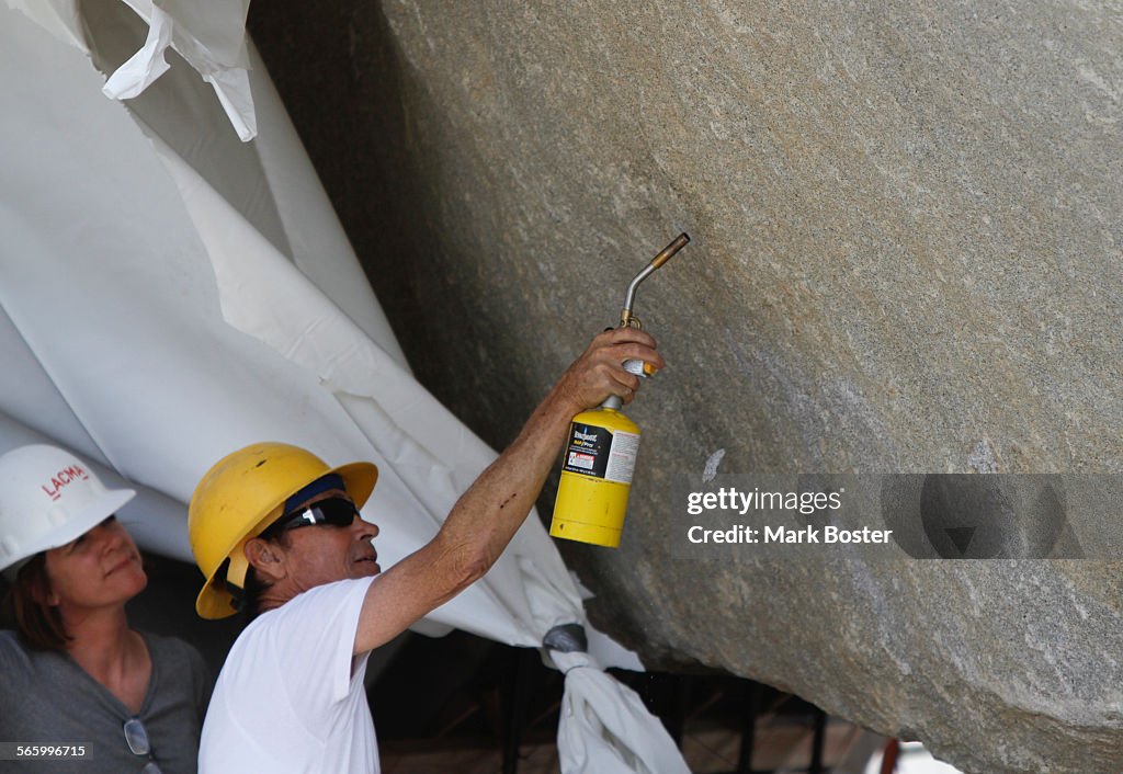 Artist Michael Heizer uses a torch while putting the finishing touches on his 340ton rock installa