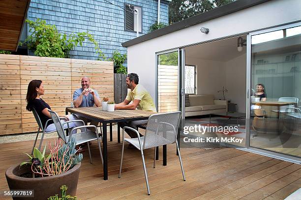 Maria Torres, boyfriend Joe Borst and friend and designer Robert Sweet sit in the outdoor dining room is a small 1952 cookie cutter home in Marina...