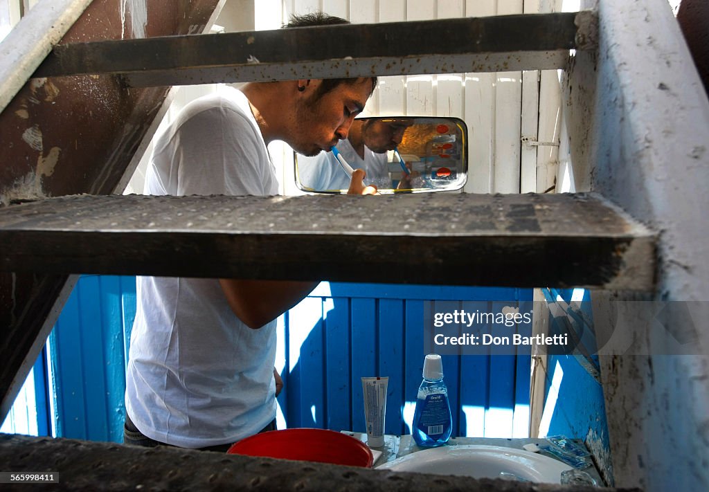 OCTOBER 11, 2011. NOGALES, MEXICO. After taking a cold water bucket bath, Luis Luna brushes his tee