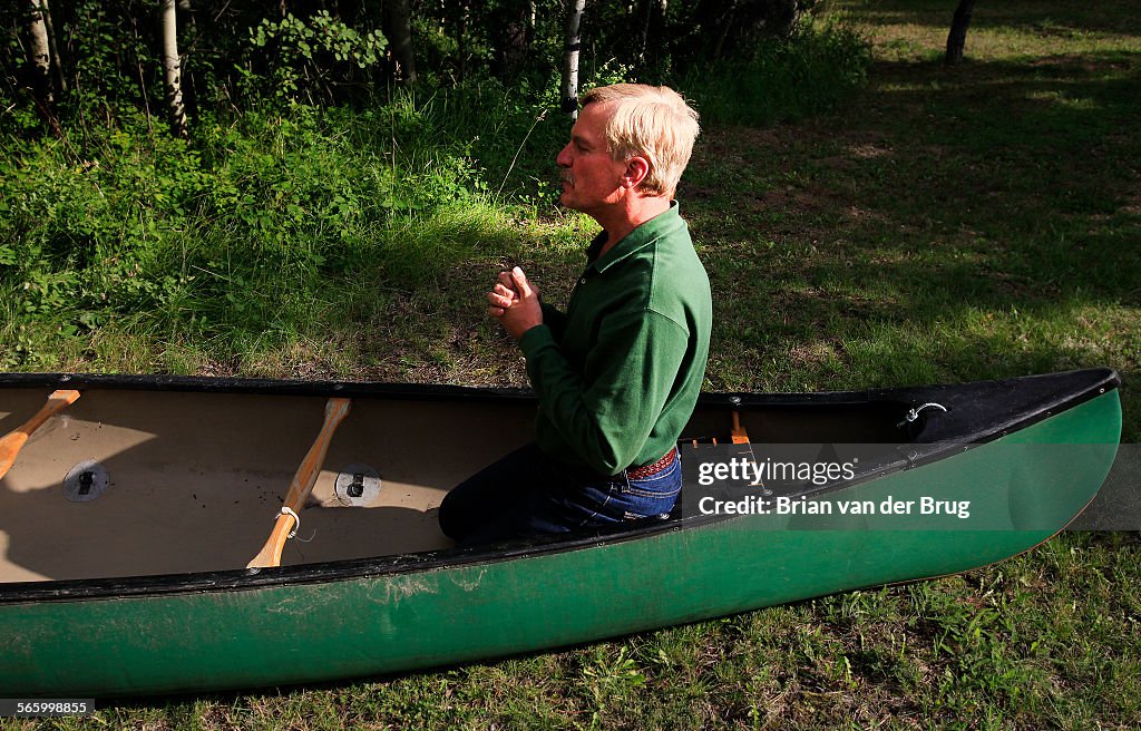 RED LODGE, MT AUGUST 19 2009 Gary Ferguson kneels in Juniper, his darkgreen 17foot Old Town Tri