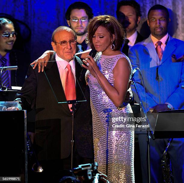 Singer Whitney Houston stands with producer Clive Davis while performing at the 2011 Clive Davis PreGrammy Gala and Salute to Industry Icons...