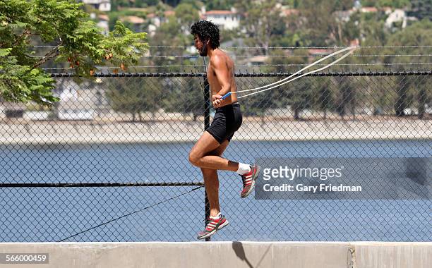 Orlando Tirado practices his balance by jumping rope on a concrete wall next to the Silver Lake reservoir along Silver Lake Blvd in Los Angeles on...
