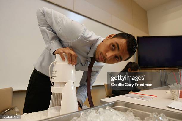 Antonio Salas prepares a raspado during a program where South Los Angeles high school students pitched their business plans for healthful products at...