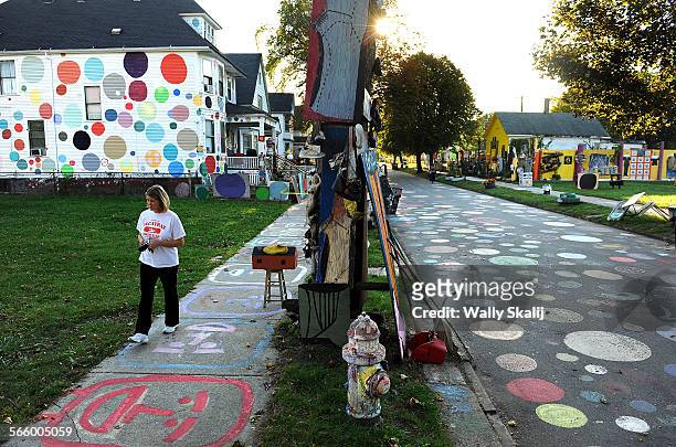 Tourist walks along Heidelberg Street in Detroit, Michigan. Over 25 years artist Tyree Guyton has transformed his childhood neighborhood into a...