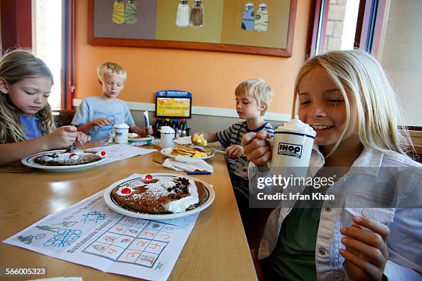 Marley Abowitz right, with her siblings 7-year-old Brody, Aidan and Ruby sips on a drink at IHOP restaurant in Los Angeles.