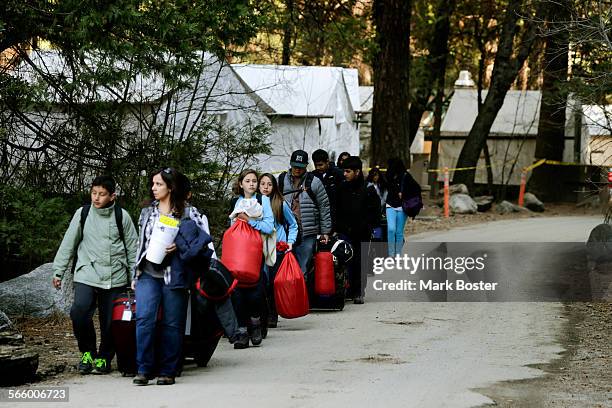 Visitors walk past the construction zone at Camp Curry in Yosemite where crews are rebuilding the tent cabins March 24, 2013. Construction and...