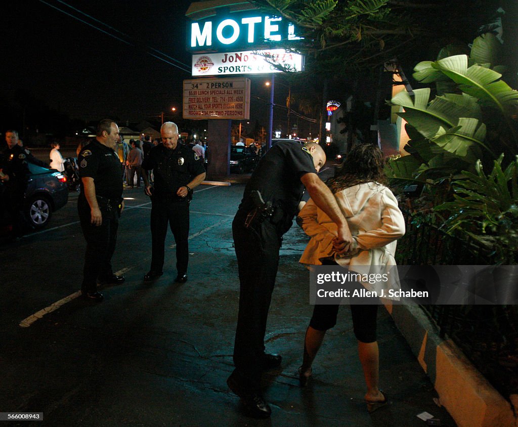Anaheim Police officer T. Hill handcuffs a woman from Fresno
