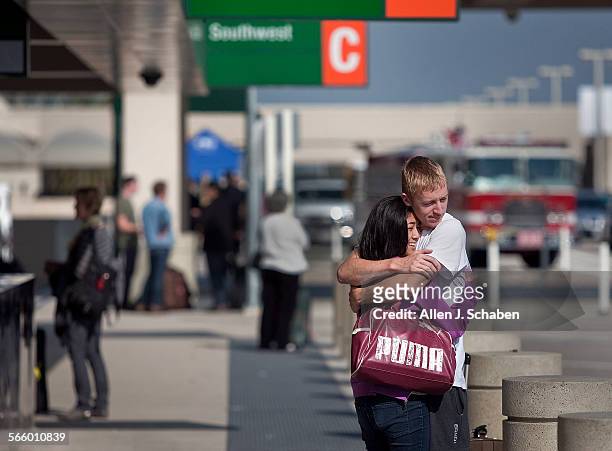 Traveler Kara Racho, of Irvine, hugs her friend, Dylan Hammergen, of Pomona, goodbye at John Wayne Airport's new Terminal C in Orange County as she...