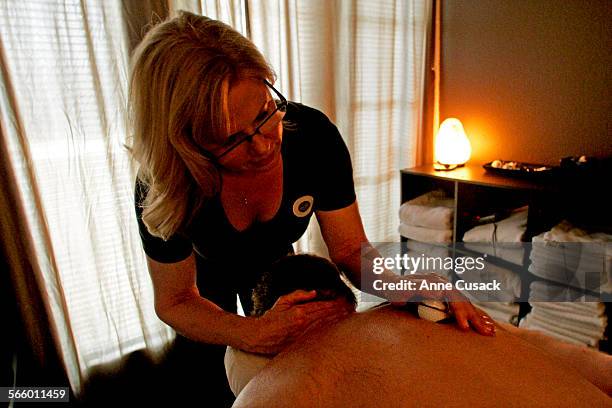 Heather Karr uses a golf ball with a spaball kaddy during a massage on Chris Erskine at Ahhhmmm Massage Therapy in Thousand Oaks on March 29, 2012.