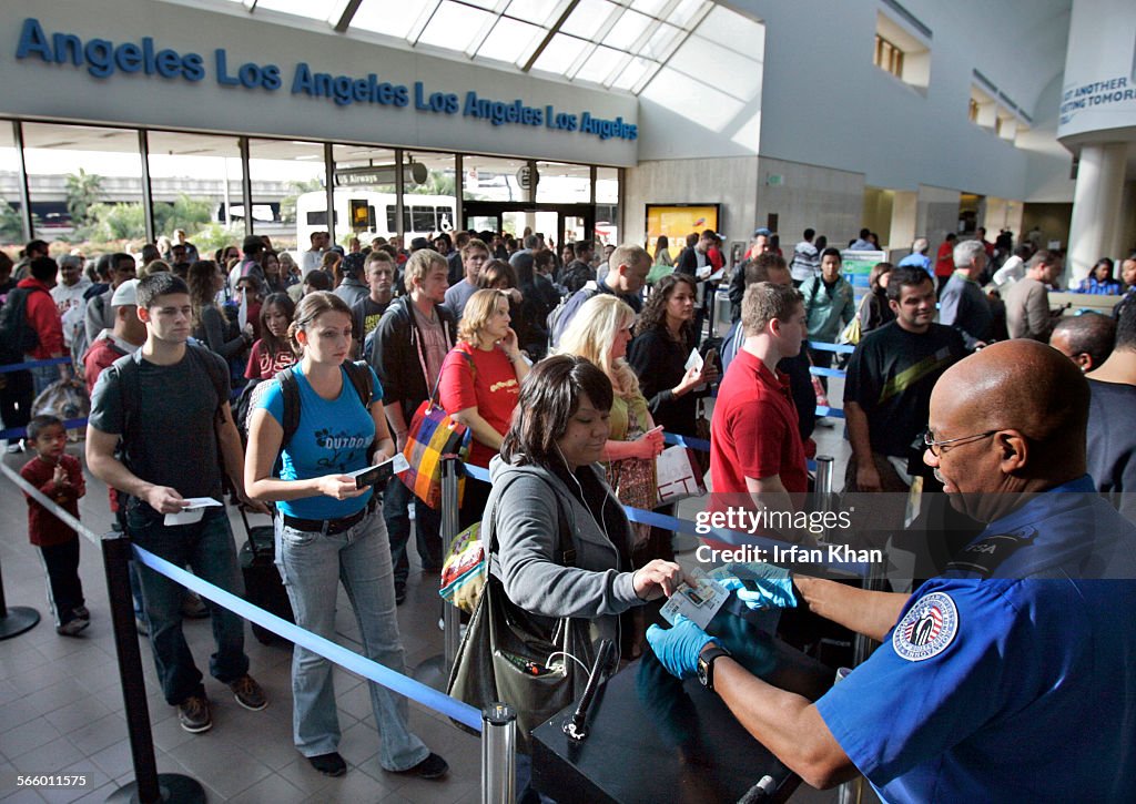 Travelers form a long security check line that is extended out of departure lounge at Los Angeles a