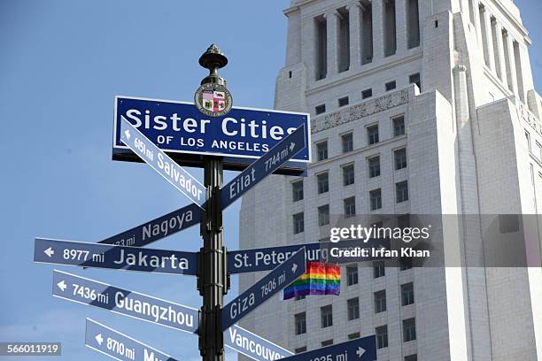 Los Angeles council members Mike Bonin, left, and Tom LaBonge pull a rope to unveil a rainbow pride flag in protest of anti-gay laws in Russia and in...