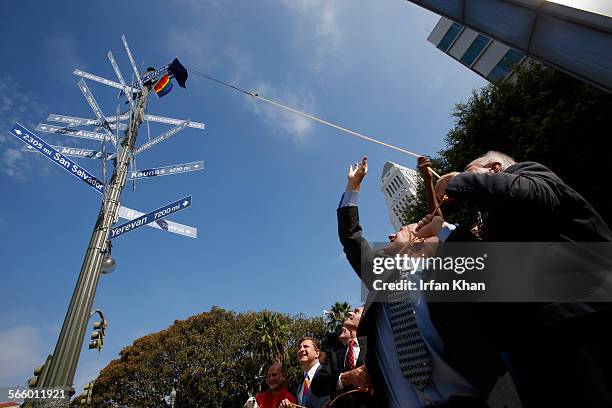 Los Angeles council members Mike Bonin, left, and Tom LaBonge pull a rope to unveil a rainbow pride flag in protest of anti-gay laws in Russia and in...