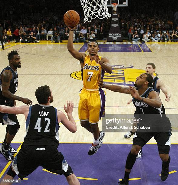 Newly acquired Laker point guard Ramon Sessions makes his first shot as a Laker past Timberwolves' Martell Webster, #5, left, Kevin Love, #42, and...