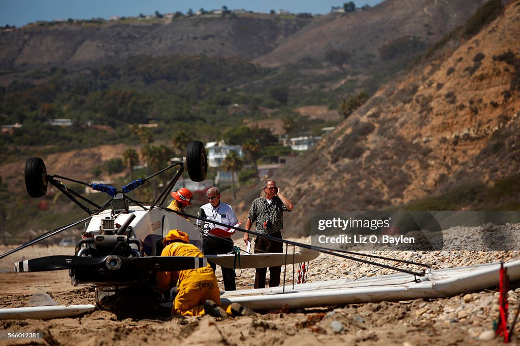 FAA investigators and local Los Angeles County Firefighters secure an airplane awaiting a recovery