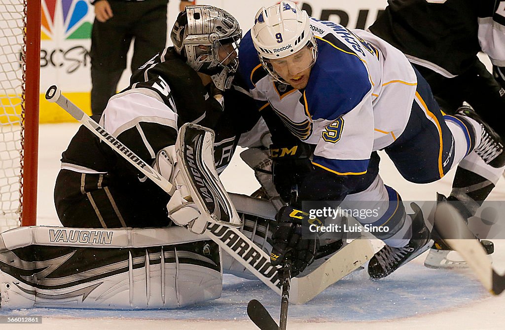 Kings goalie Johnathan Quick and Blues left wing Jaden Schwatrz collide in front of the goal in the