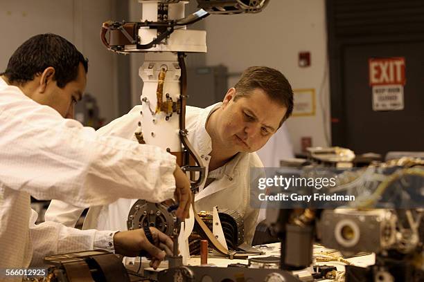 Wes Kuykendall and Luis Dominguez , test analysts for Mars Science Laboratory, work on the Vehicle System Testbed rover at the Jet Propulsion...