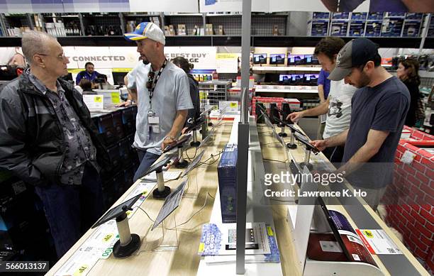 Best Buy customers browsing/handling new tablet computer devices like the Kindle Fire and Barnes and Noble Nook on Nov. 21, 2011.