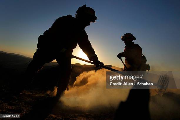At sunset, Cal Fire firefighter hand crews from Miramonte knock down a fast-moving Silver fire that has scorched more than 10,000 acres, burned about...