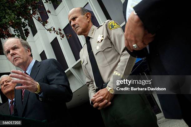 Sheriff Lee Baca, listens to Robert Bonner, former head of U.S. Drug Enforcment Administration at the podium, during a press conference outside...