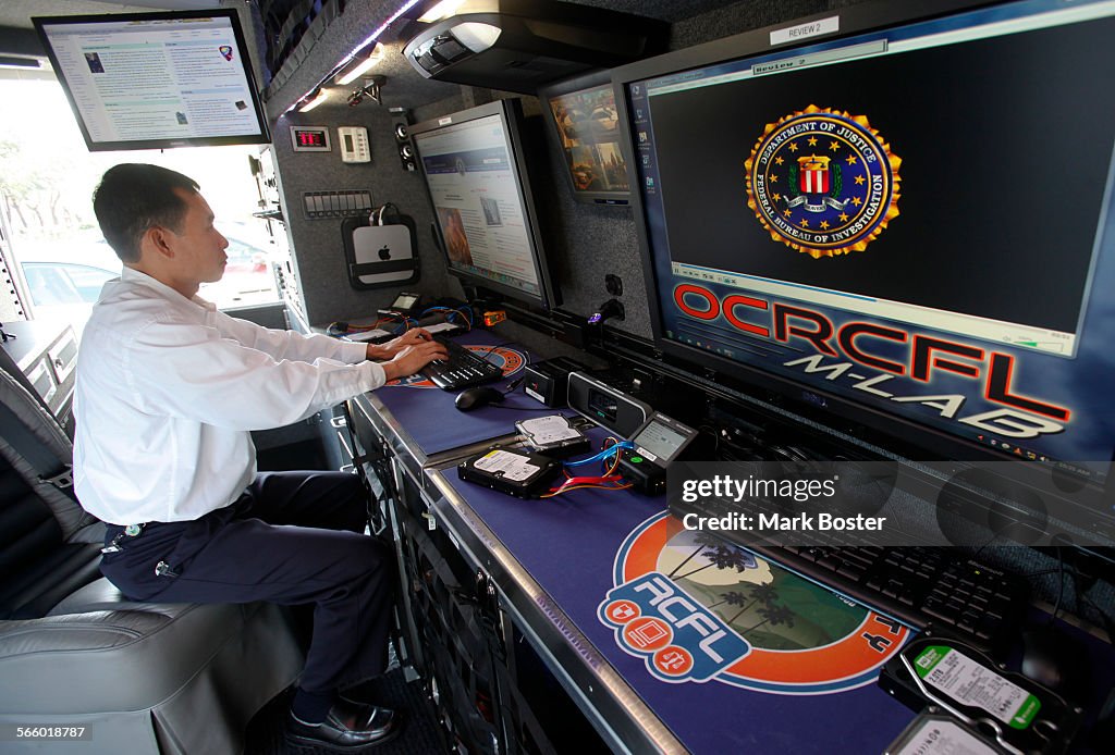 FBI computer expert Nhan Nguyen works at the console inside the FBI ...