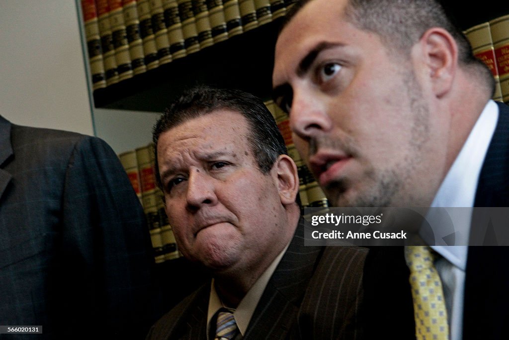 L to R Bell City Councilman Luis Artiga (CQ) reacts as he makes a statement that he is resigning as