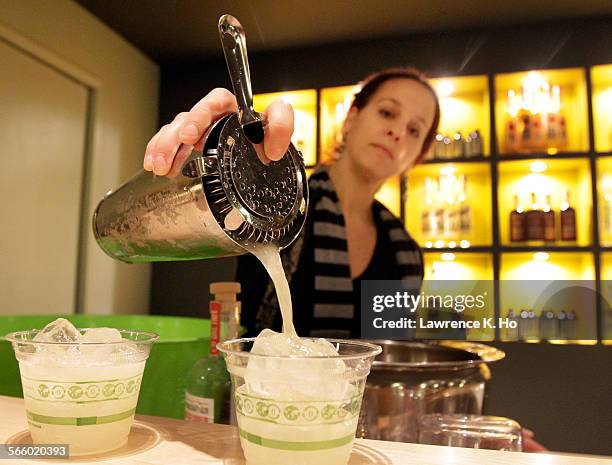 Bartender Tina Migliorino serves the Slow Hand White Whiskey cocktail named Honey Bear at Greenbar's tasting room before the Group tour at Greenbar...