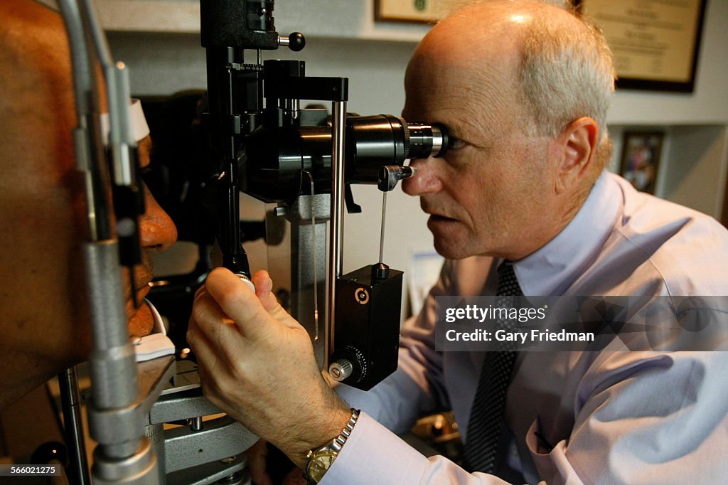 Robert Shapiro (right), Doctor of Optometry, examines a patient at Family Eyecare on October 3, 201