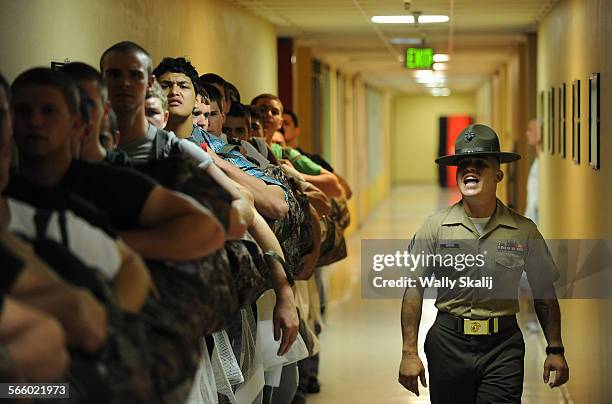 Drill Instructor Juan Garcia shouts instructions to new recruits before haircuts on the 1st day of boot camp at the Marine Corps Recruit Depot in San...