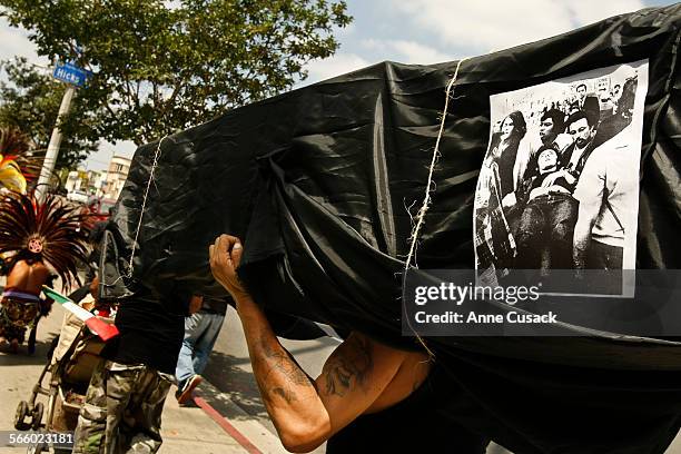 Charles Aguayo carries a coffin with a photo of a shooting victim from August 29, 1970 as a march is held on Whittier Boulevard in East Los Angeles...